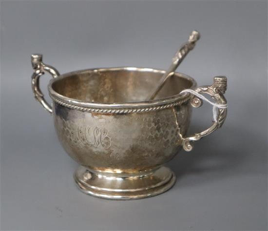A George V Albert Edward Jones Arts and Crafts silver christening porringer and spoon, Birmingham, 1921/2, spoon 12.9cm.